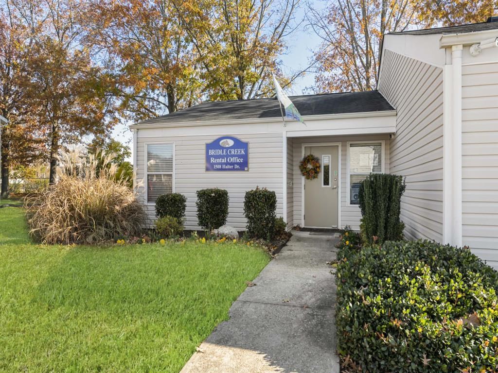 a white building with a white door and a blue sign on it