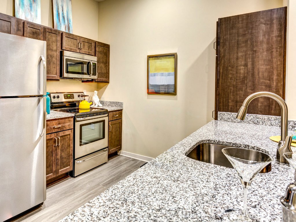A kitchen with a granite counter top and a sink.