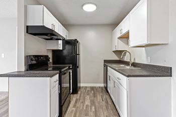 a kitchen with white cabinets and black appliances at Village 1373, Greensboro, NC, 27455