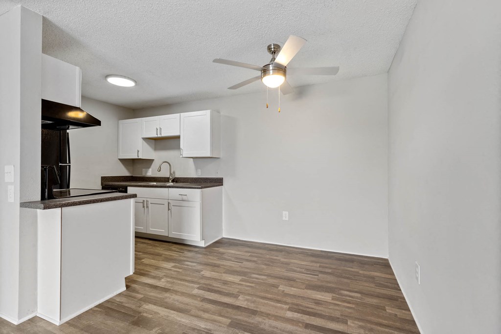 an empty living room and kitchen with a ceiling fan at Village 1373, North Carolina