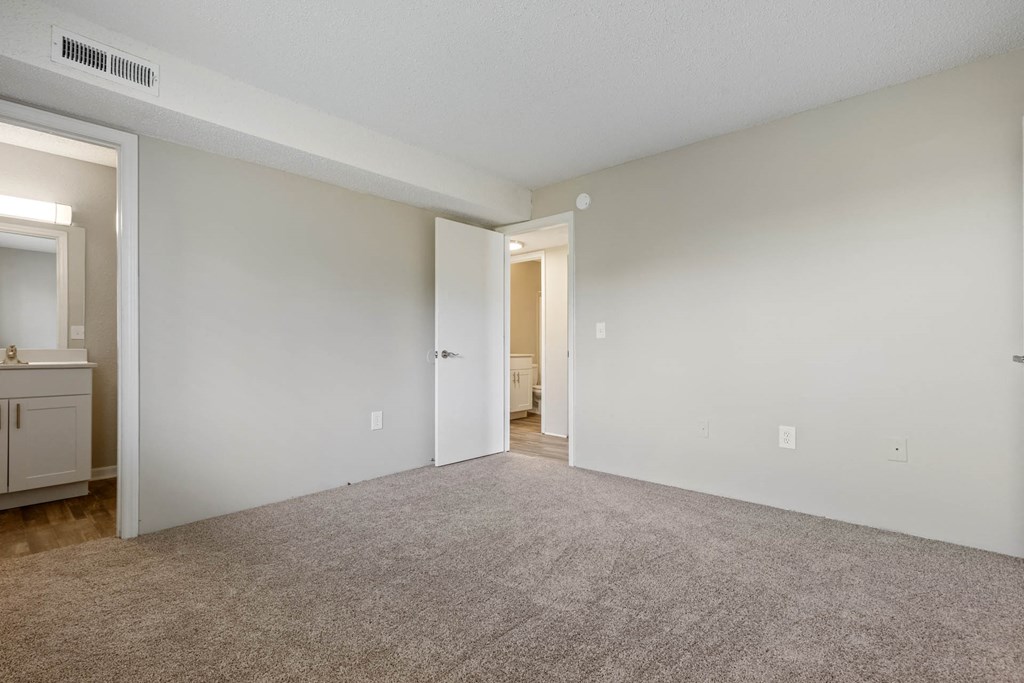 a spacious living room with carpeting and white walls at Village 1373, Greensboro
