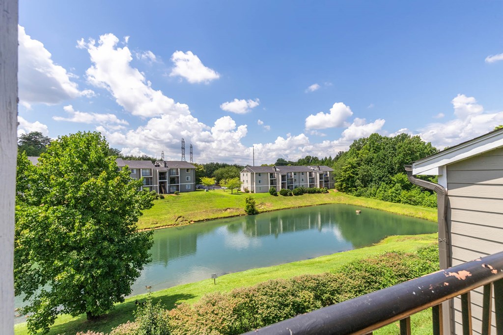 a view of a pond with apartments in the background at Village 1373, Greensboro, 27455