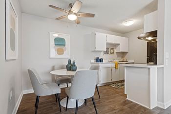 a dining room and kitchen with white cabinets and a ceiling fan at Village 1373, Greensboro, NC 27455