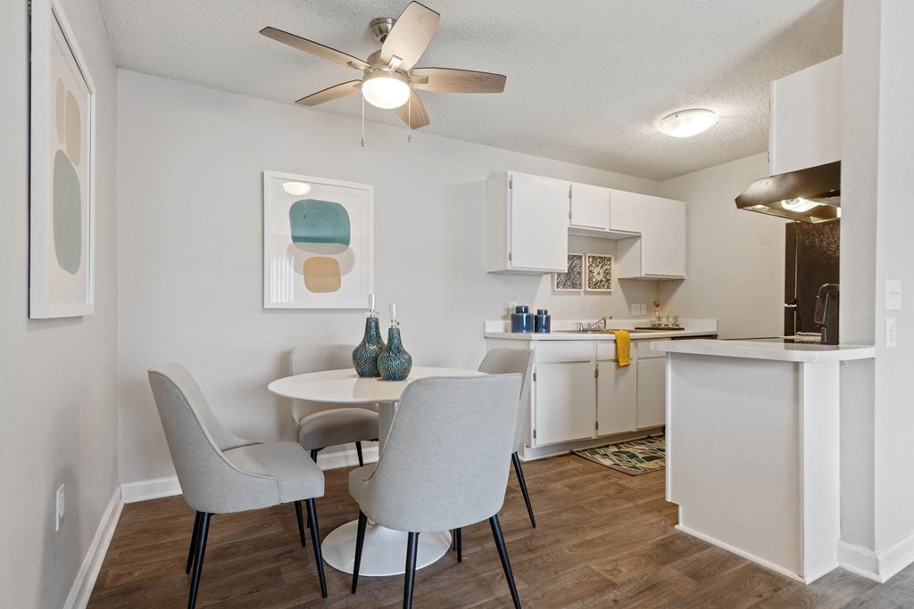 a dining room and kitchen with white cabinets and a ceiling fan at Village 1373, Greensboro, NC