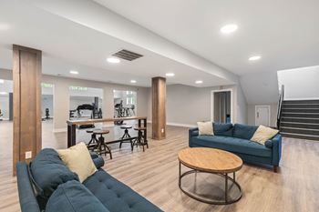 a living room with couches and a bar and a staircase at Village 1373, Greensboro, NC