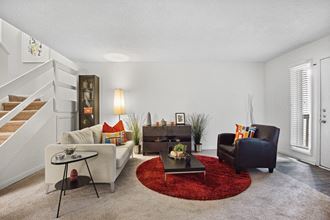 a living room with white walls and a red rug