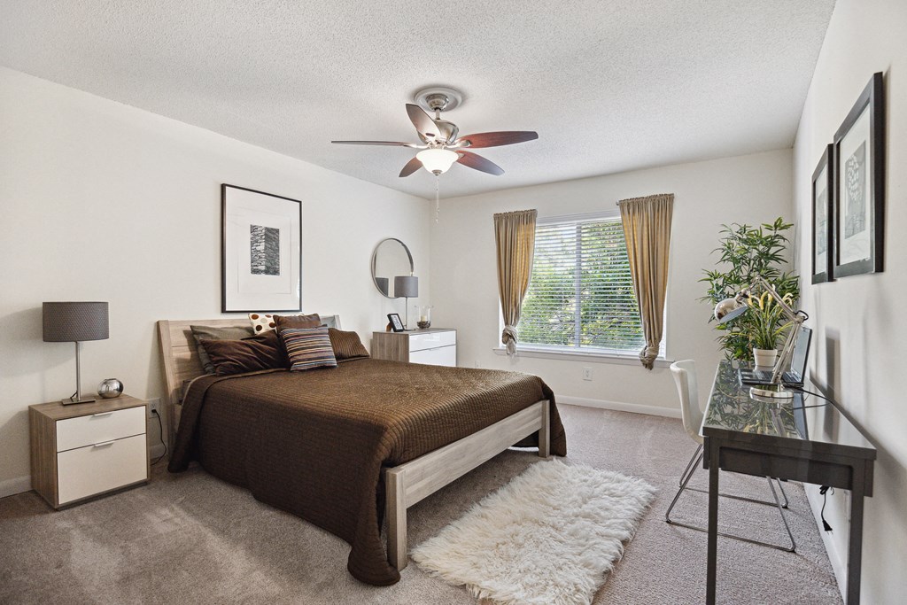 a bedroom with a large bed and a ceiling fan