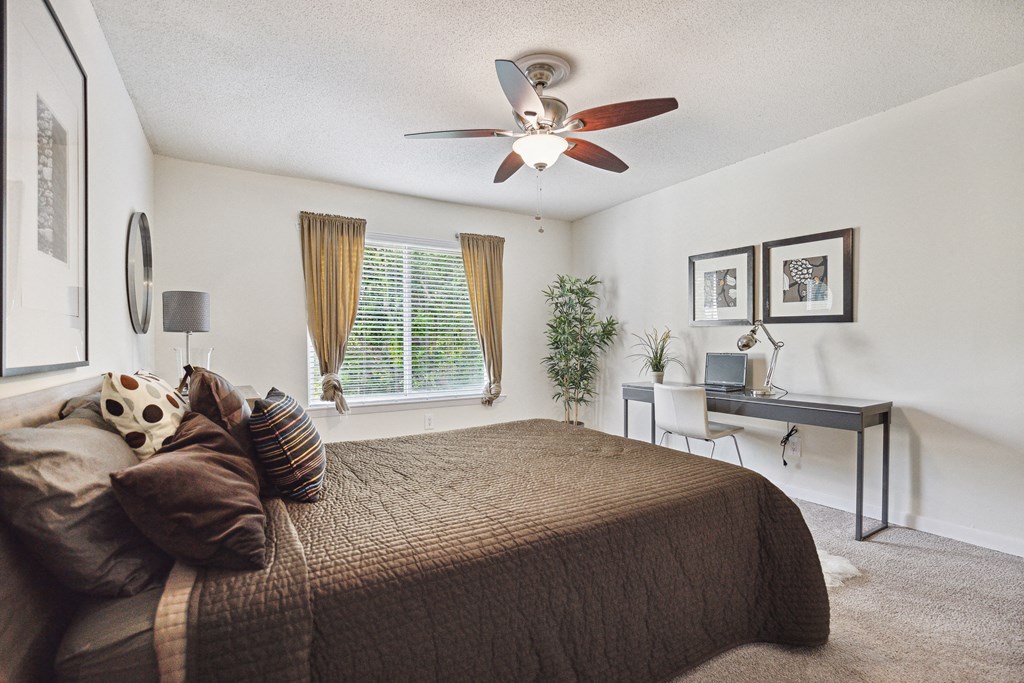 a bedroom with a large bed and a ceiling fan