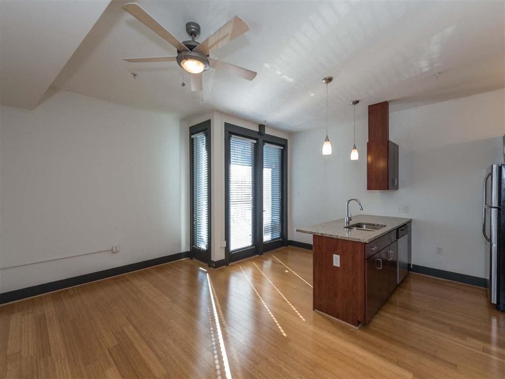 Living room with hardwood floors at The Masonry Apartments