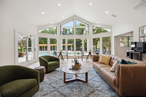 A living room with a brown couch, green armchair, and a coffee table with a plant on it.