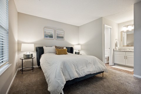 a bedroom with a bed and a bathroom in the background at Wendover River Oaks, Greensboro, NC