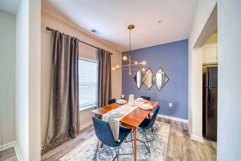 A dining room with a wooden table and chairs.
