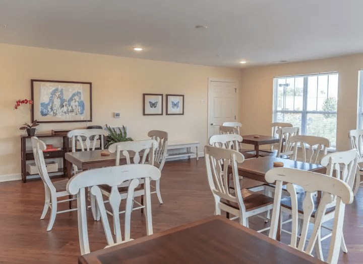 a dining room with white chairs and tables