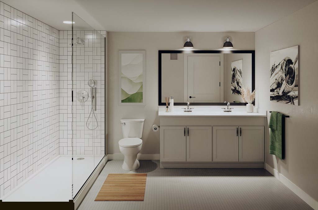A white tiled bathroom with a toilet, sink, and shower.at Aviator Lofts, Newport News, 23602