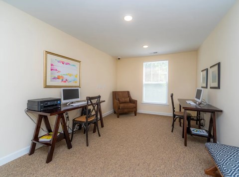 a home office with a computer and a desk with a chair