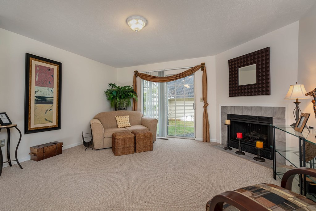 A living room with a fireplace and a couch.at Camden Place, Dublin Ohio