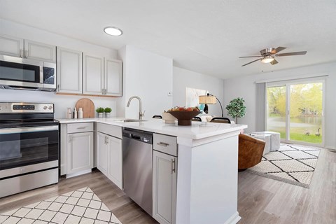 A modern kitchen with white cabinets and stainless steel appliances.
