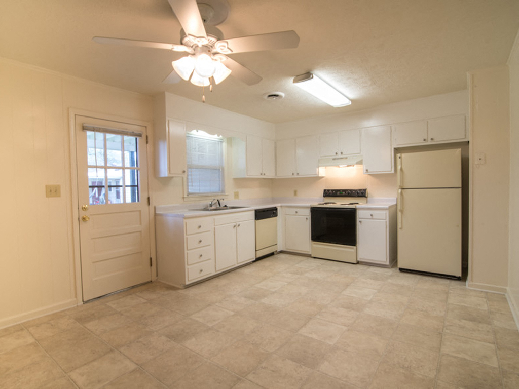A kitchen with white cabinets and appliances.