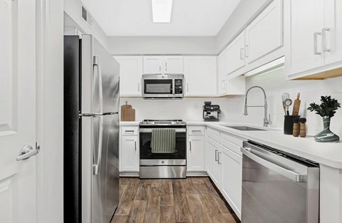 A modern kitchen with stainless steel appliances and white cabinets.