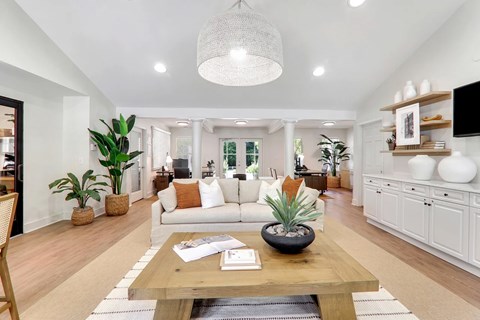 A living room with a white couch and a wooden coffee table.