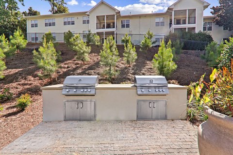 Two BBQs are in front of a building.