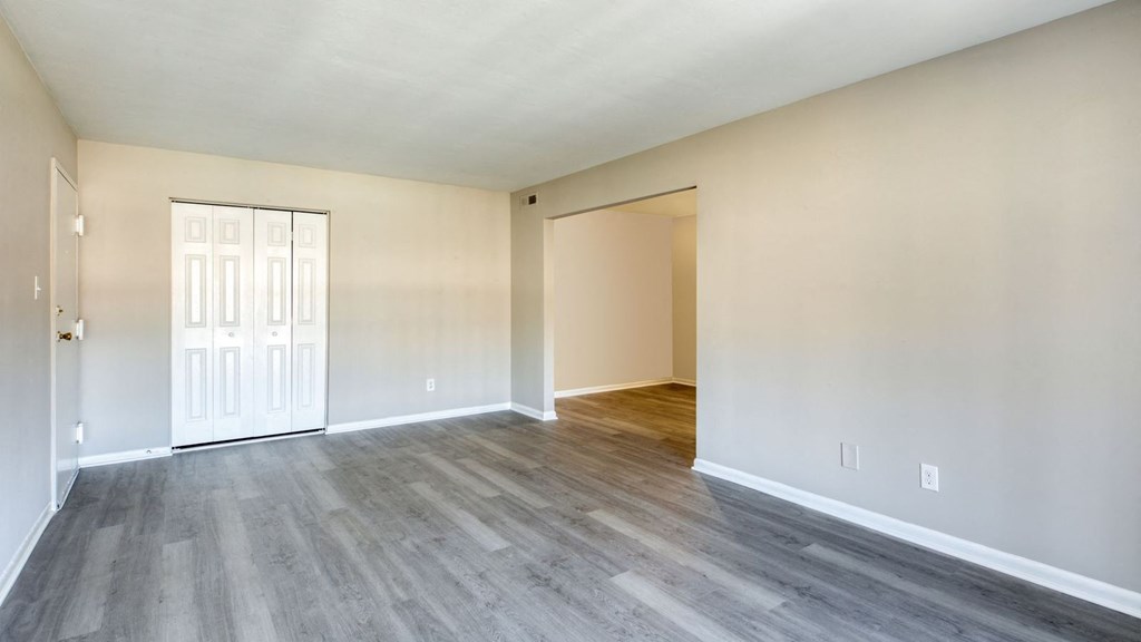 an empty living room with white walls and wood flooring at Bayville Apartments, Virginia Beach