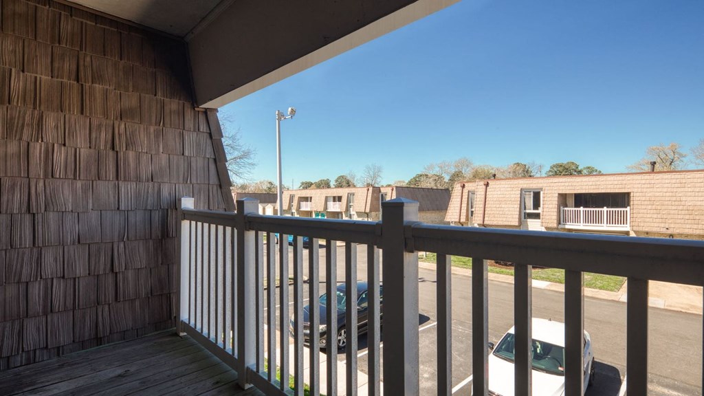 a view from the balcony of a building with a car in the parking lot  at Bayville Apartments, Virginia Beach, VA, 23455
