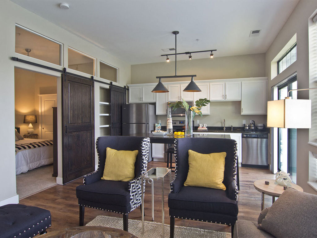 A modern kitchen with black chairs and a dining table.