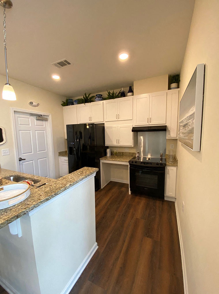A kitchen with black appliances and white cabinets.