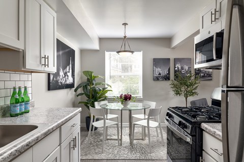 A kitchen with a table and chairs in the middle.