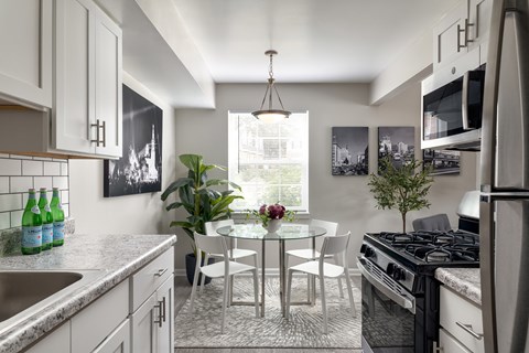 A modern kitchen with a dining table and chairs.