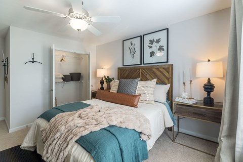 A bedroom with a bed covered in a white and blue comforter.