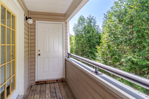 A white door is on the porch of a house.