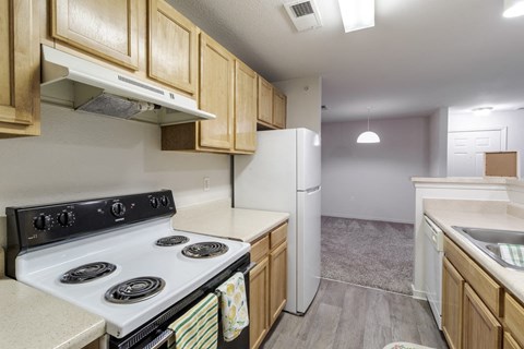 A kitchen with a white stove top oven and white refrigerator.