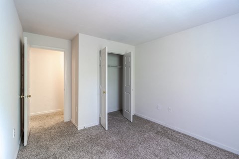 A room with carpeted floor and two doors.