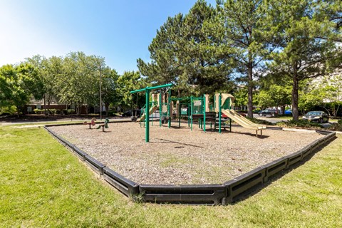 A playground with a green slide and a black base.