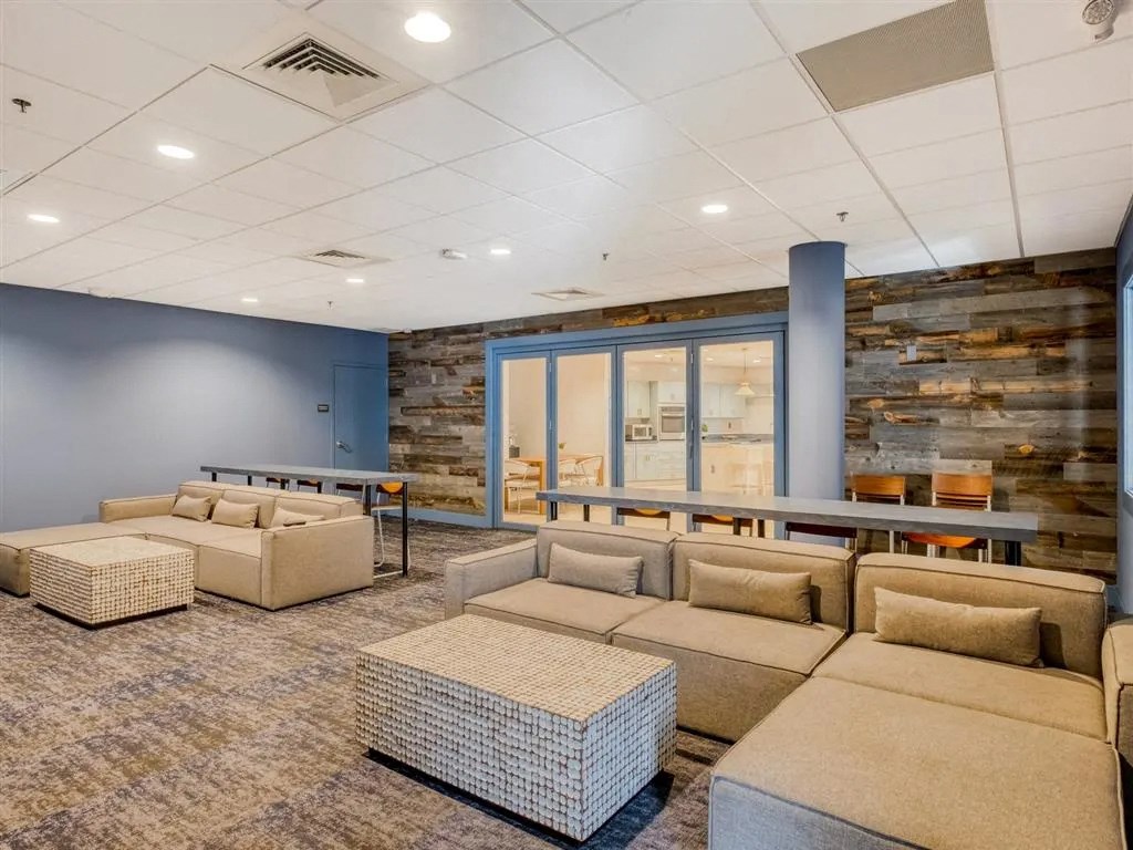 a lounge area with couches and a table with chairs