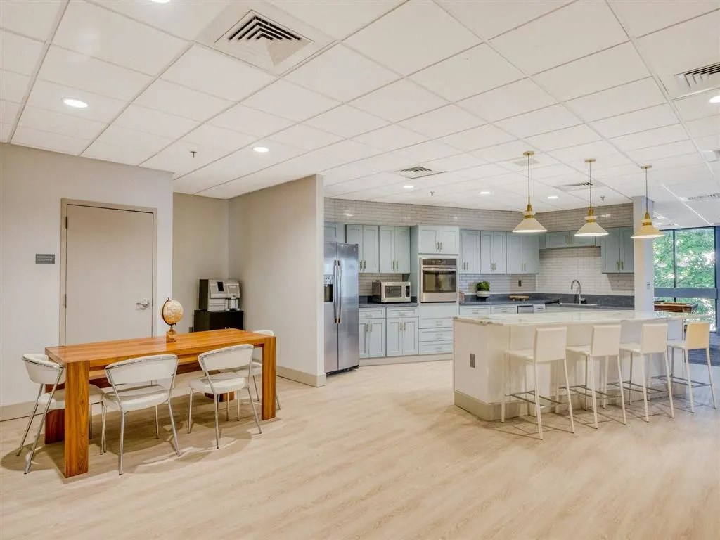 an open kitchen and dining room with white chairs and a table