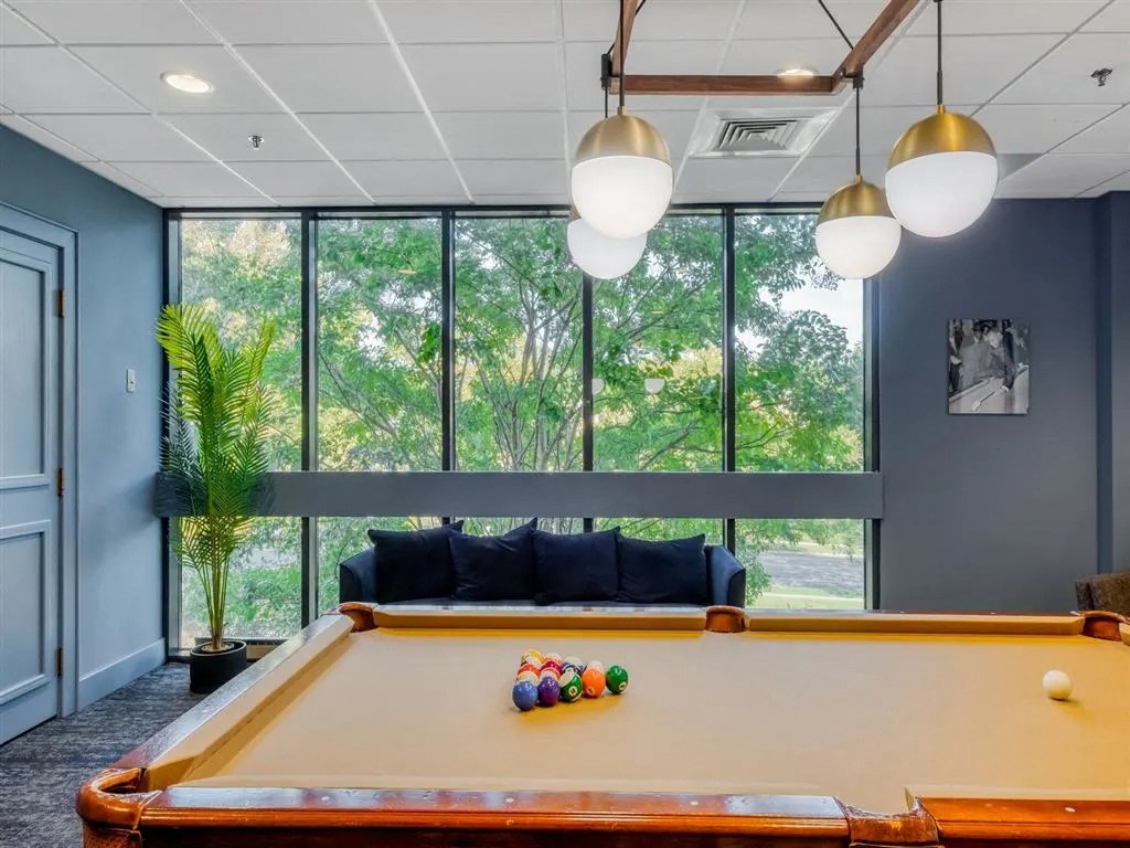 a pool table in a room with large windows
