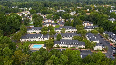 A bird's eye view of a residential area with houses and a swimming pool.