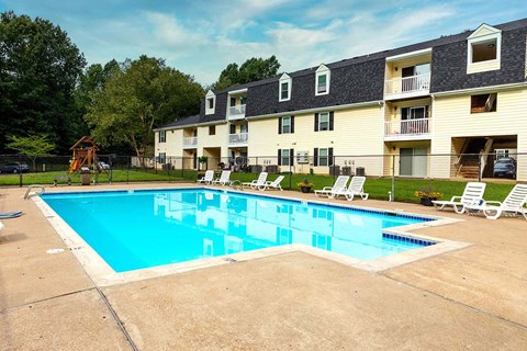A large swimming pool in front of apartment buildings.