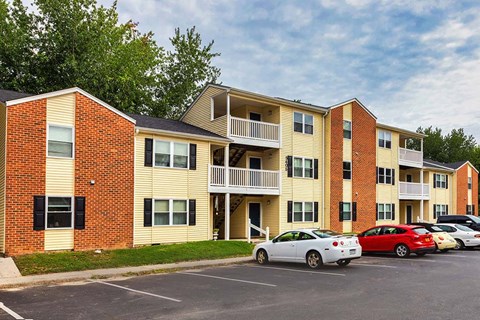 A parking lot with cars and apartment buildings.