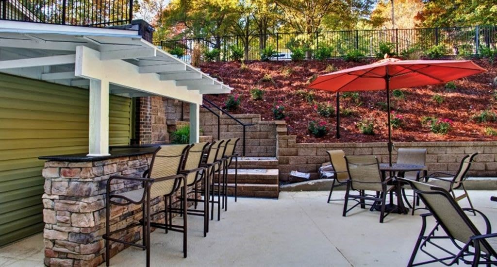 a patio with chairs and an umbrella