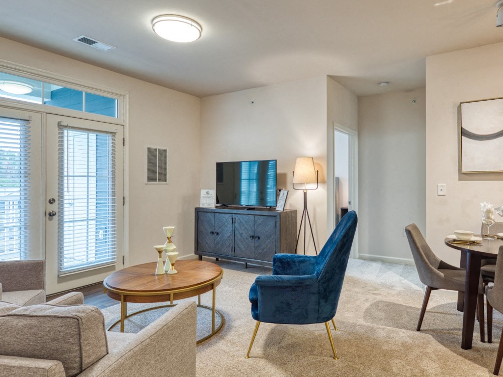 a living room with a couch and chairs and a tv