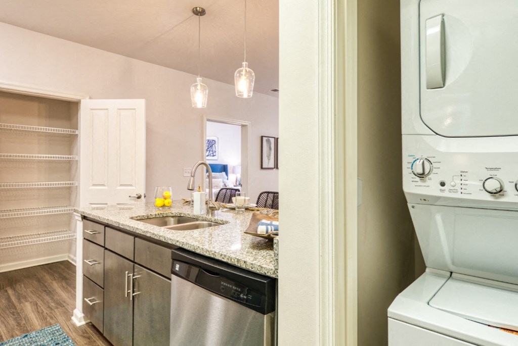 a kitchen with a washer and dryer and a sink