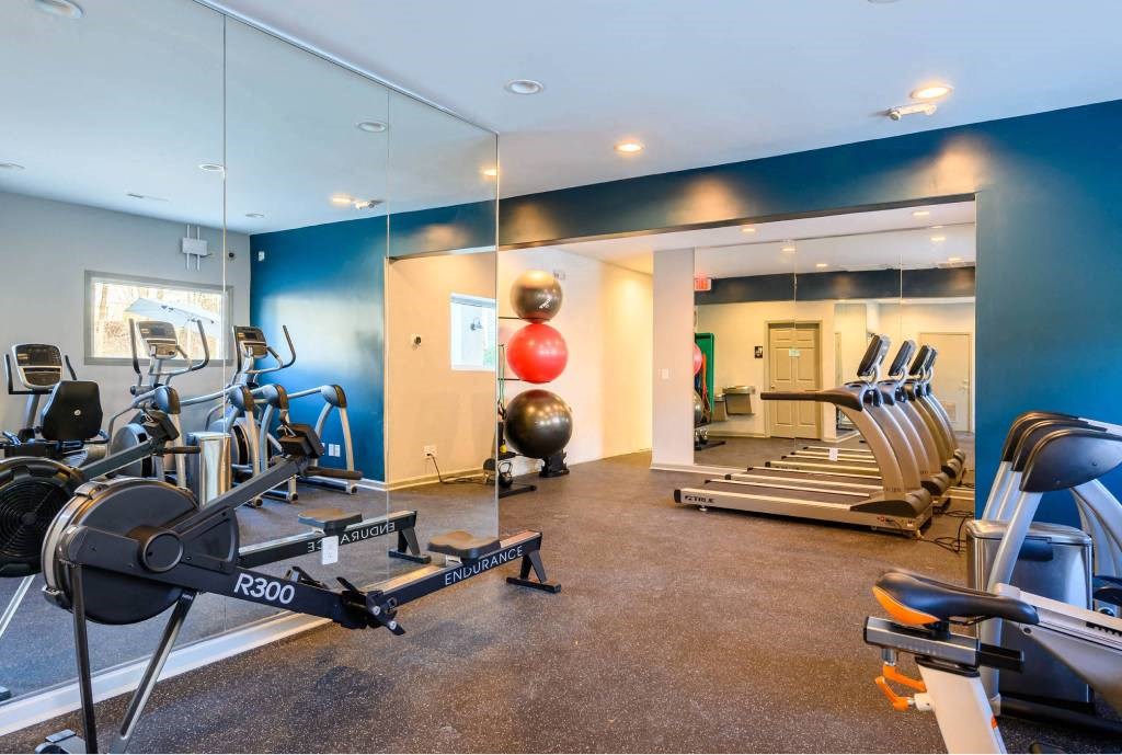 A gym with a row of exercise bikes and a treadmill.