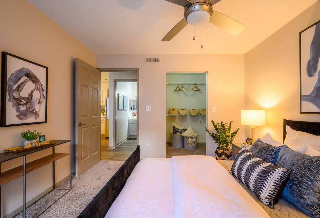 A bedroom with a large bed and a ceiling fan.