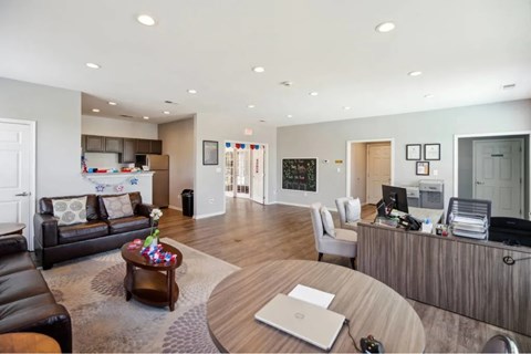 A modern living room with a black leather couch and a wooden coffee table.