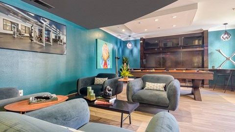 A living room with a pool table and a painting of a woman.