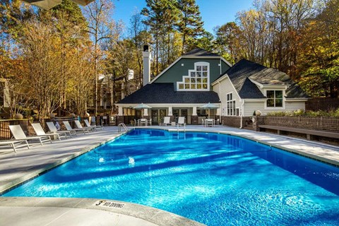 A large swimming pool in front of a house.